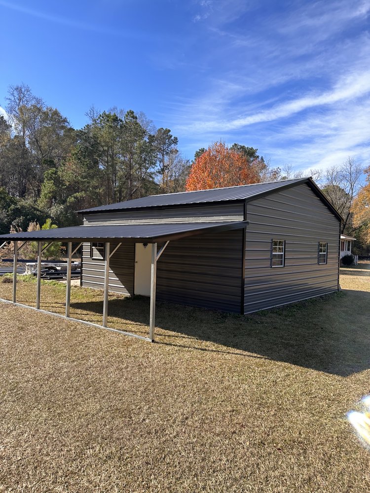 Gray prefab steel building with attached lean-to on a rural North Carolina property